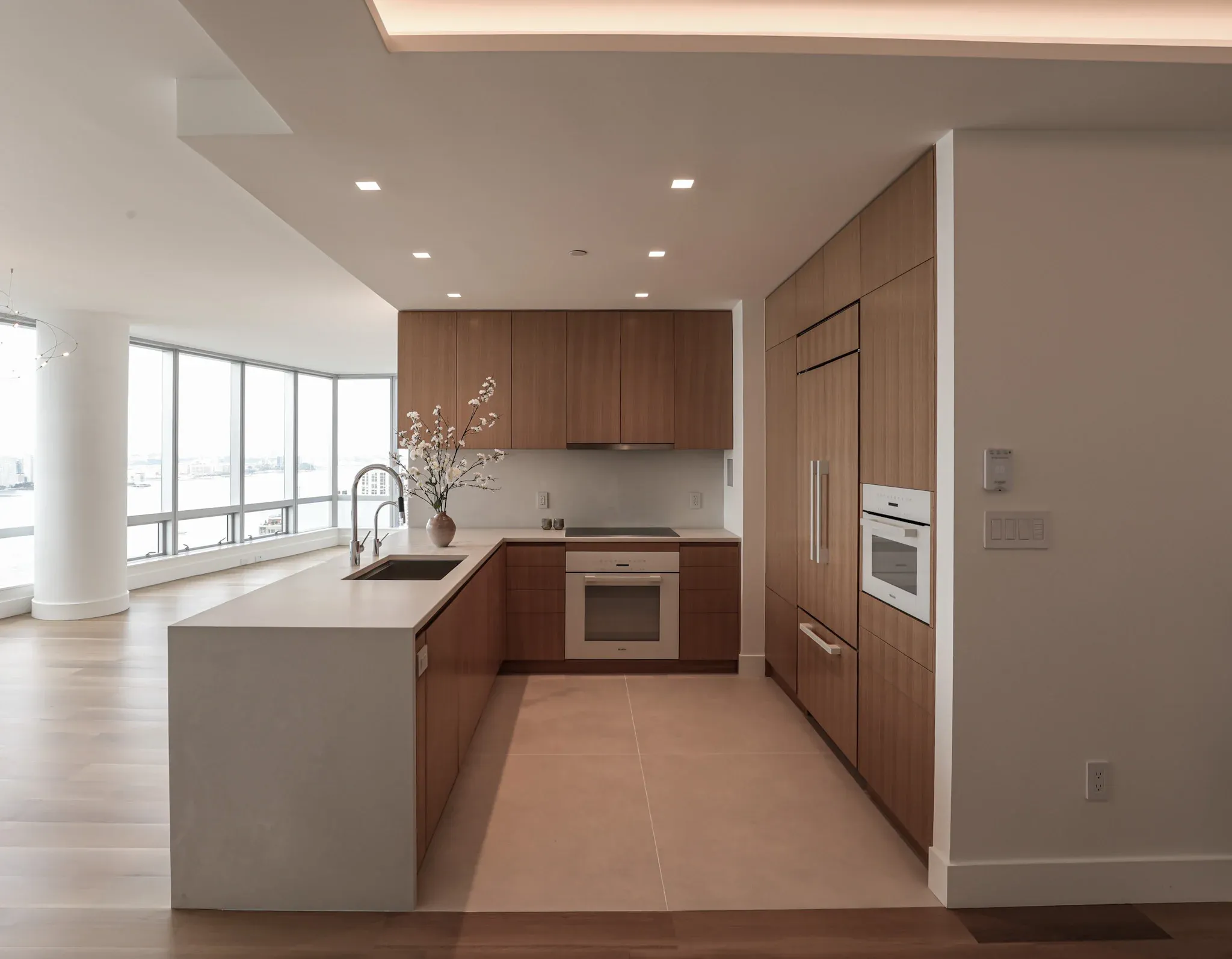 A walnut and white kitchen with a long island and wall ovens